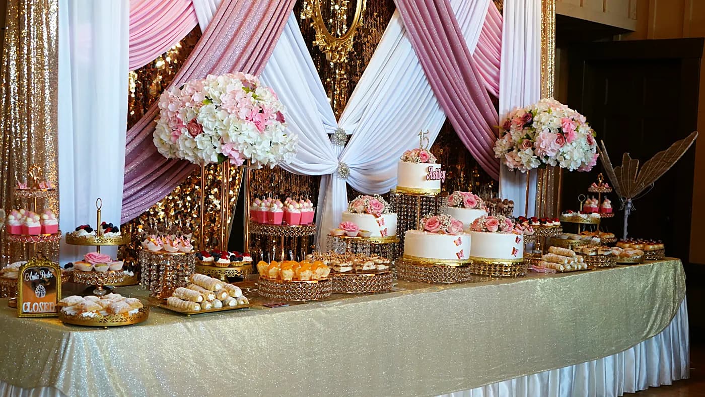 Mesa de postres con pasteles y flores rosas